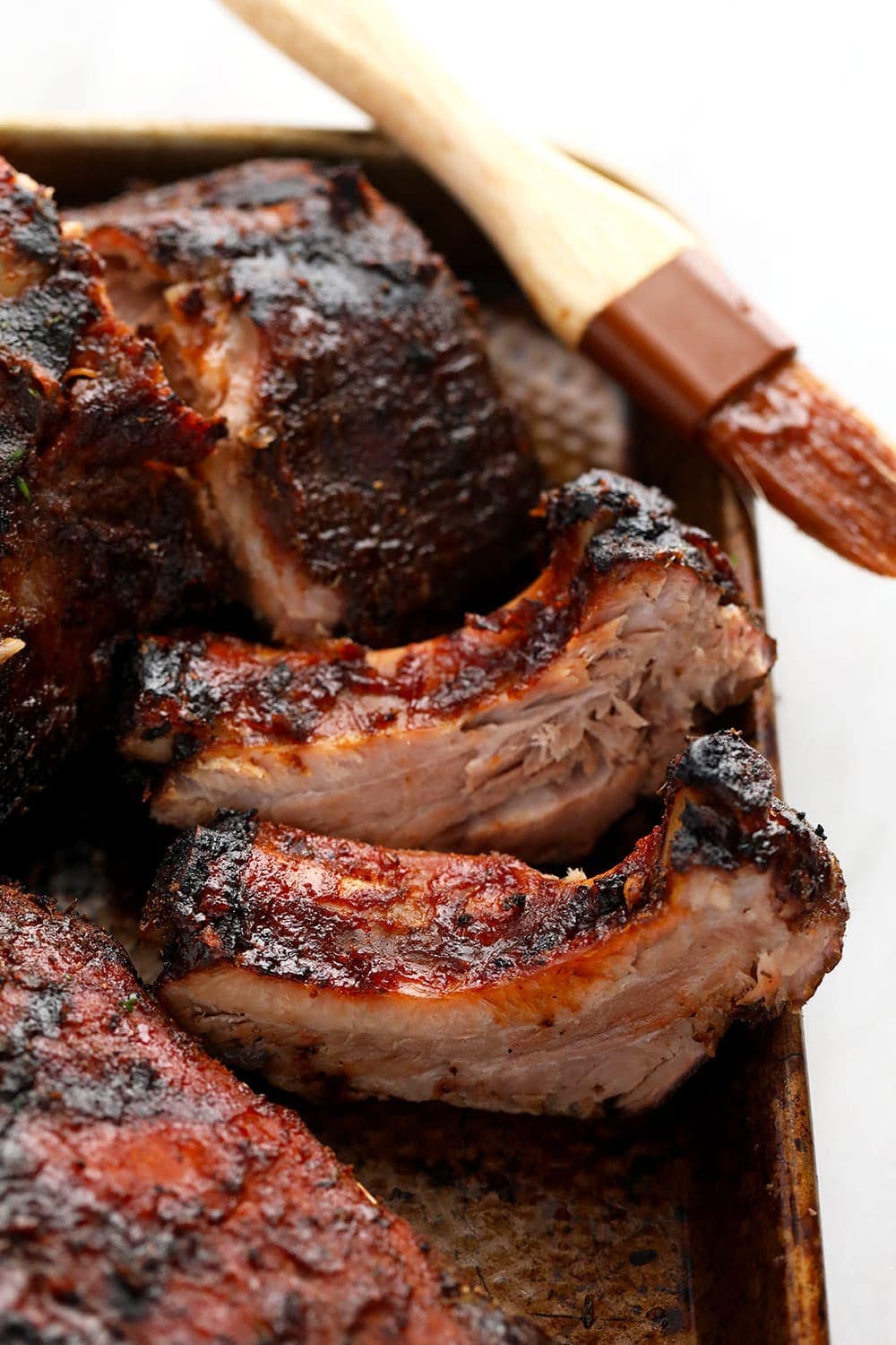 Sous Vide Ribs on a baking sheet with sauce brush