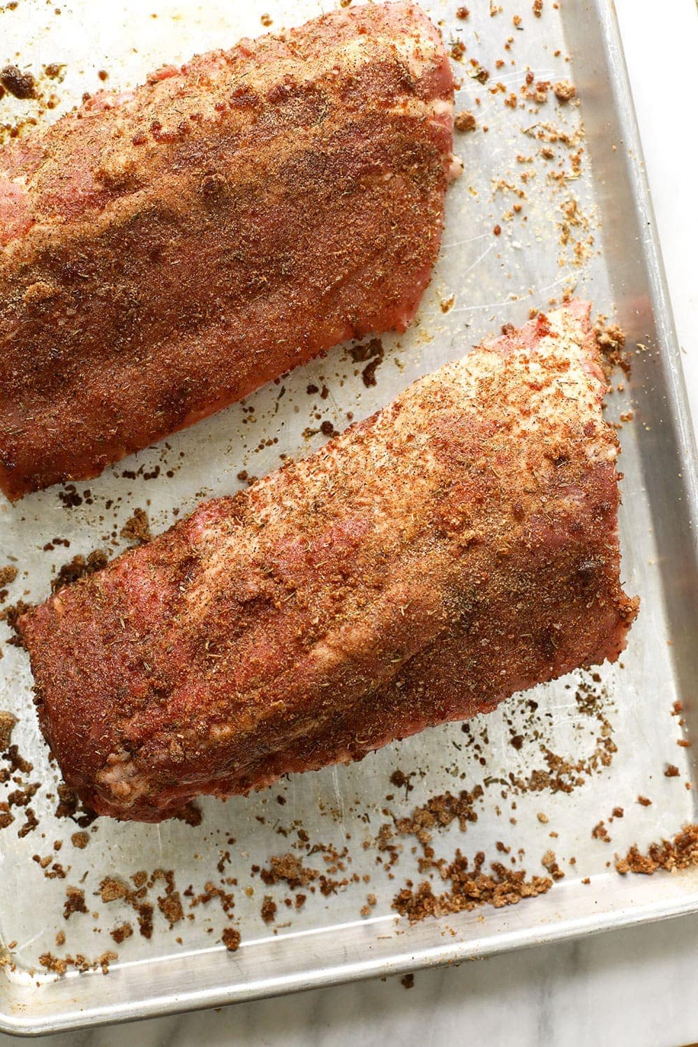 Dry rubbed sous vide ribs on a baking sheet.