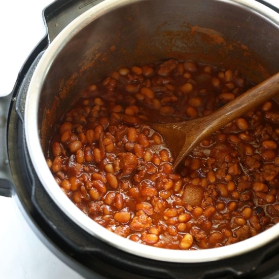 Instant Pot baked beans cooked with a wooden spoon.