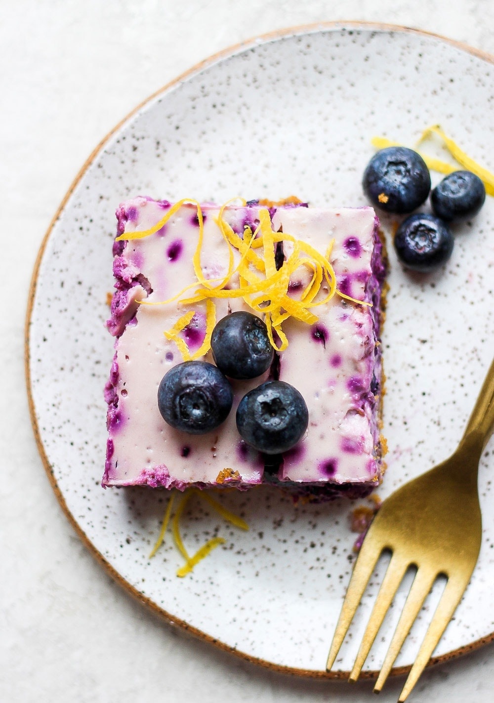 blueberry cheesecake bar on a plate ready to enjoy