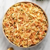creamy coleslaw in a bowl topped with parsley