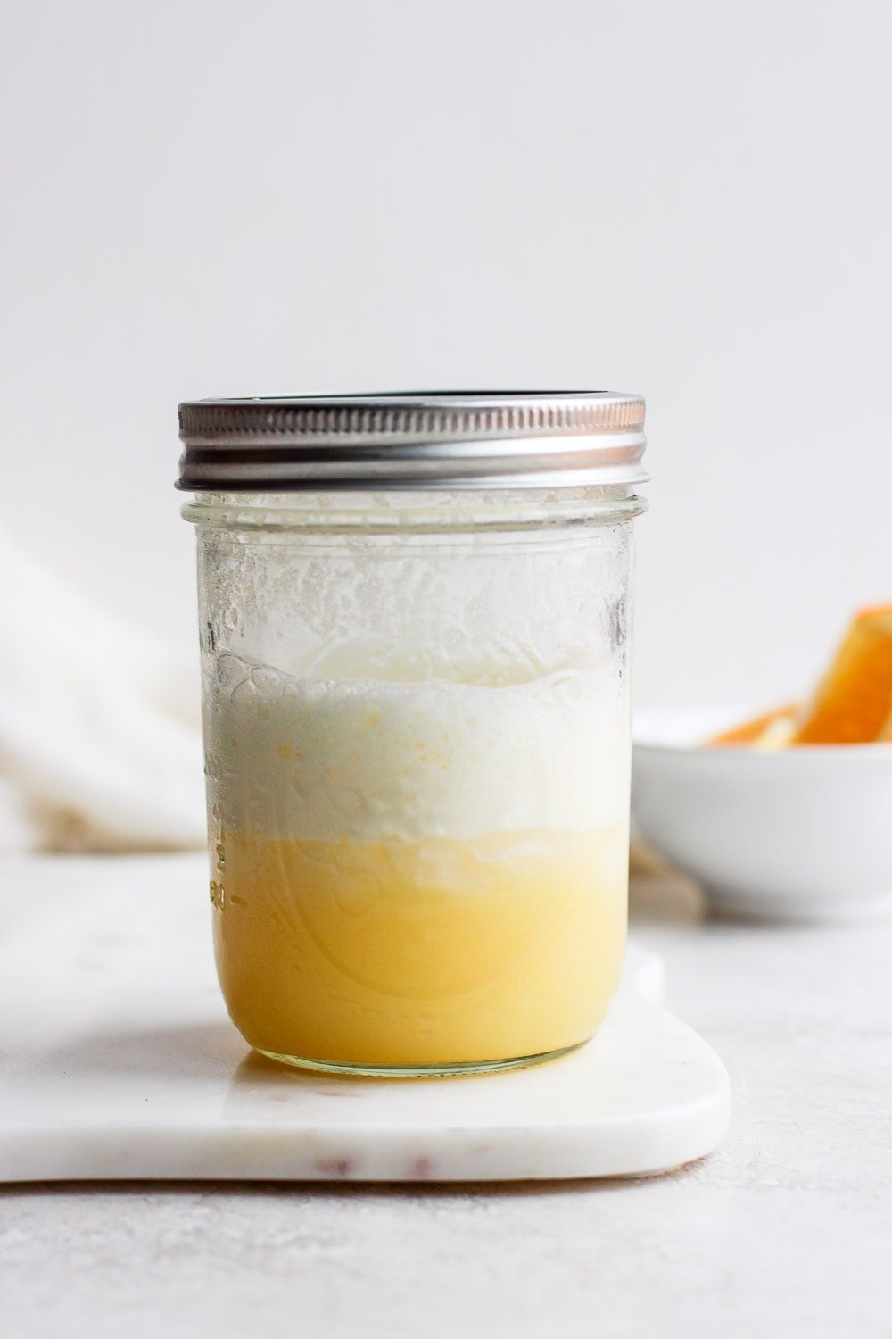 An orange creamsicle smoothie in a mason jar