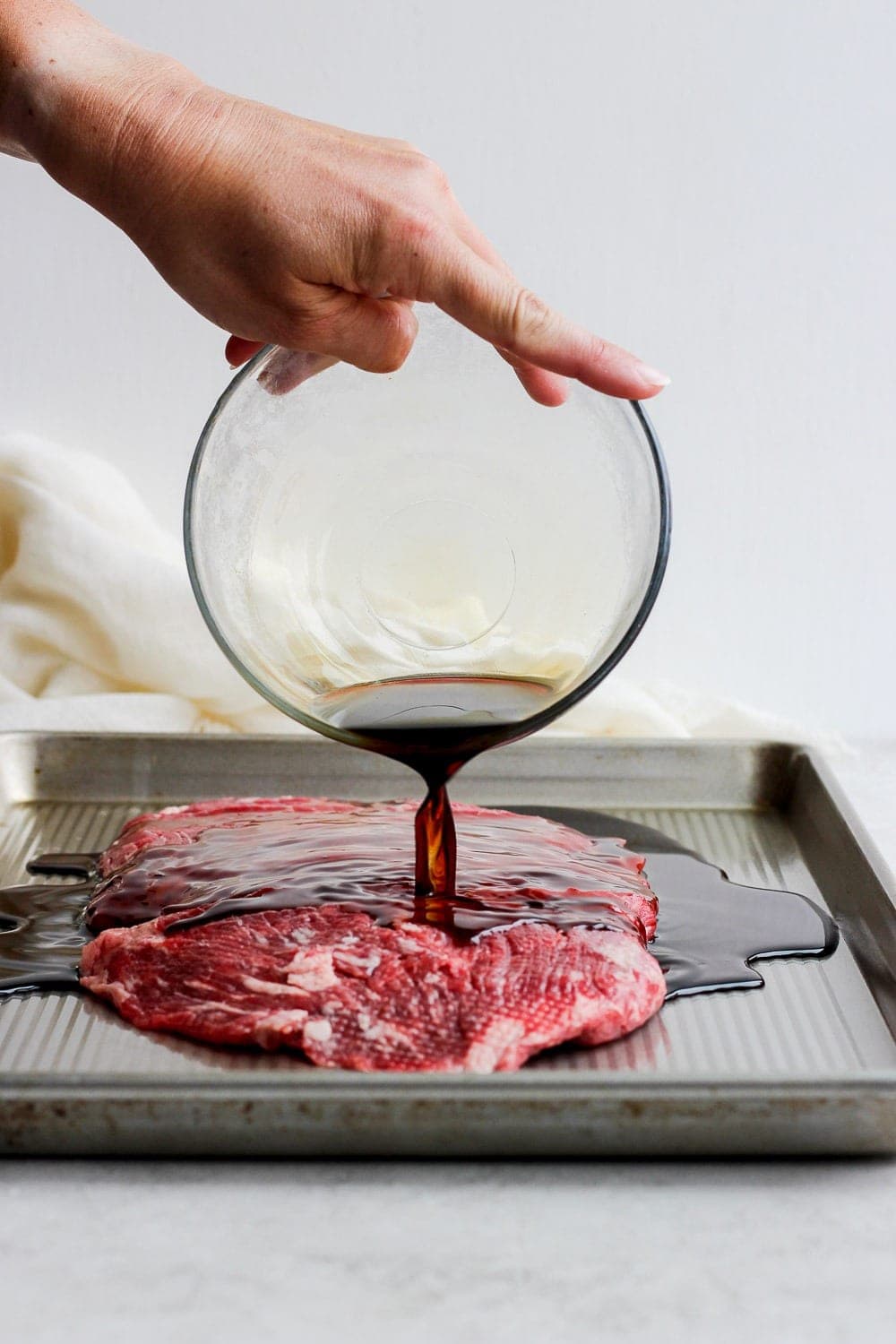 Marinade being poured over flank steak.