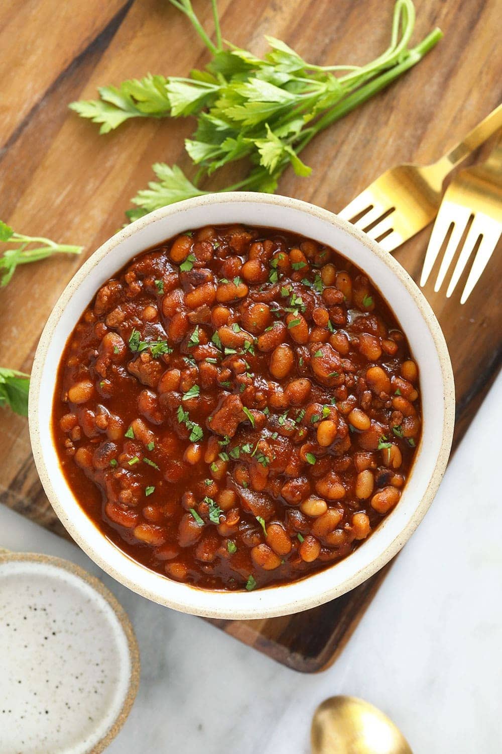 Instant Pot Baked Beans in a bowl topped with parsley. 
