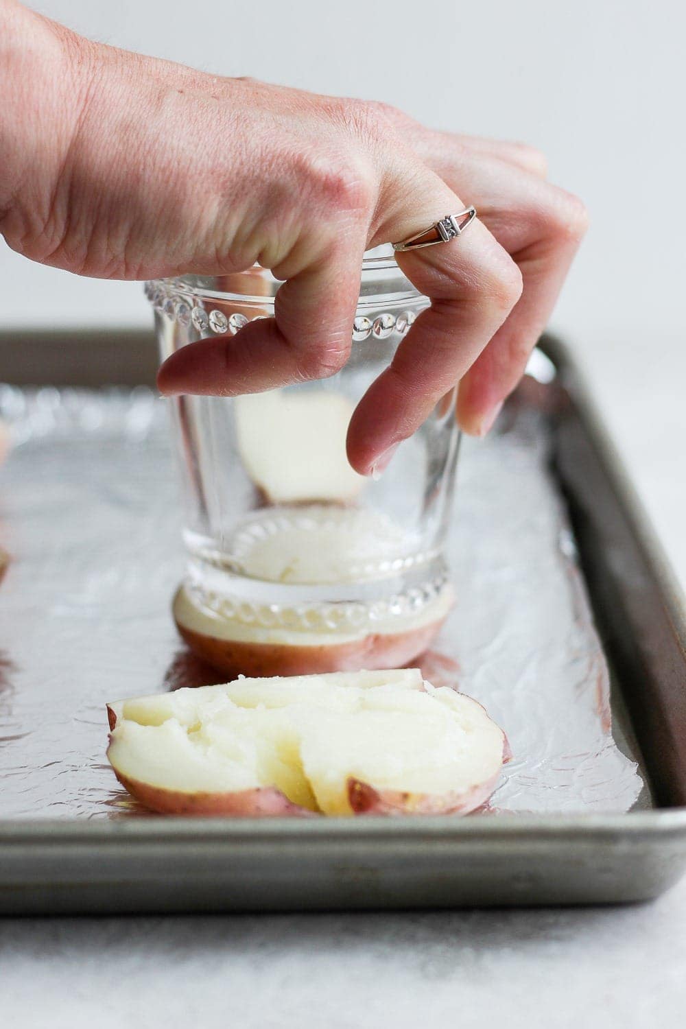 Smashing a boiled red potato with the bottom of a cup! 