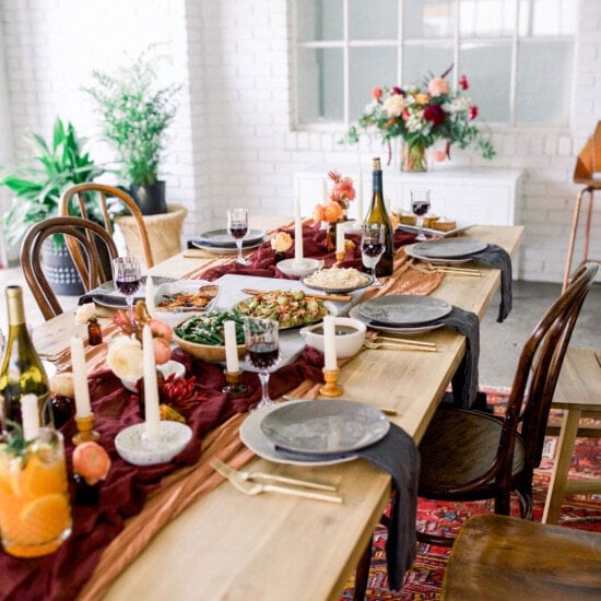 A festive Thanksgiving table setting featuring beautifully arranged wine glasses and plates.