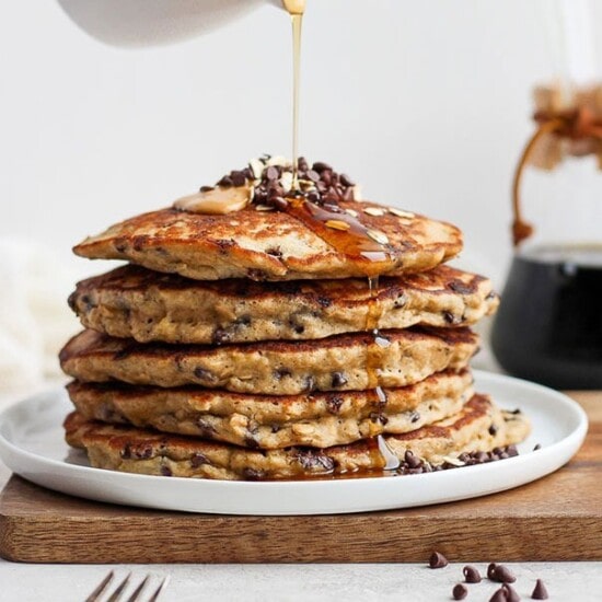 A stack of fit foodie finds pancakes being drizzled with syrup.