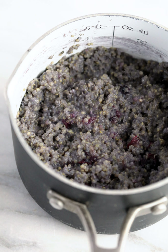 Blueberry breakfast quinoa being cooked in a pot. 