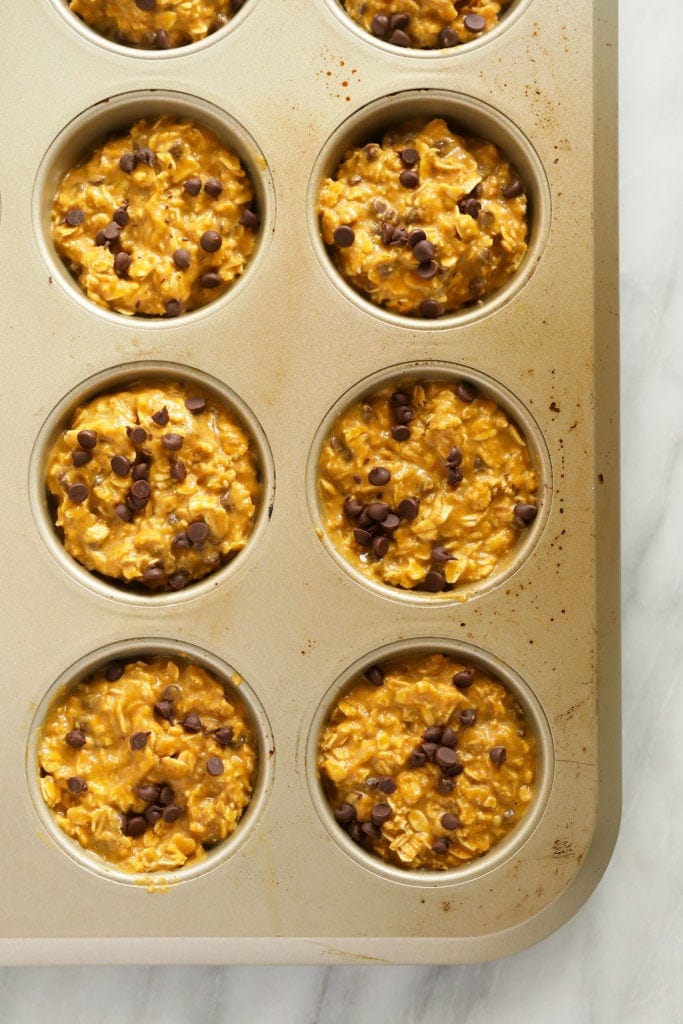 Pumpkin oatmeal cups in a muffin tin ready to go in the oven.