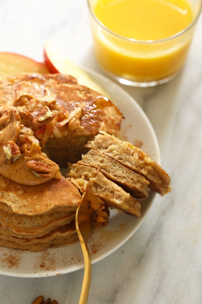 A fork with pancake on it on plate.