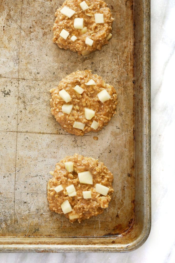 Apple oatmeal cookies on a baking sheet before they are baked. 