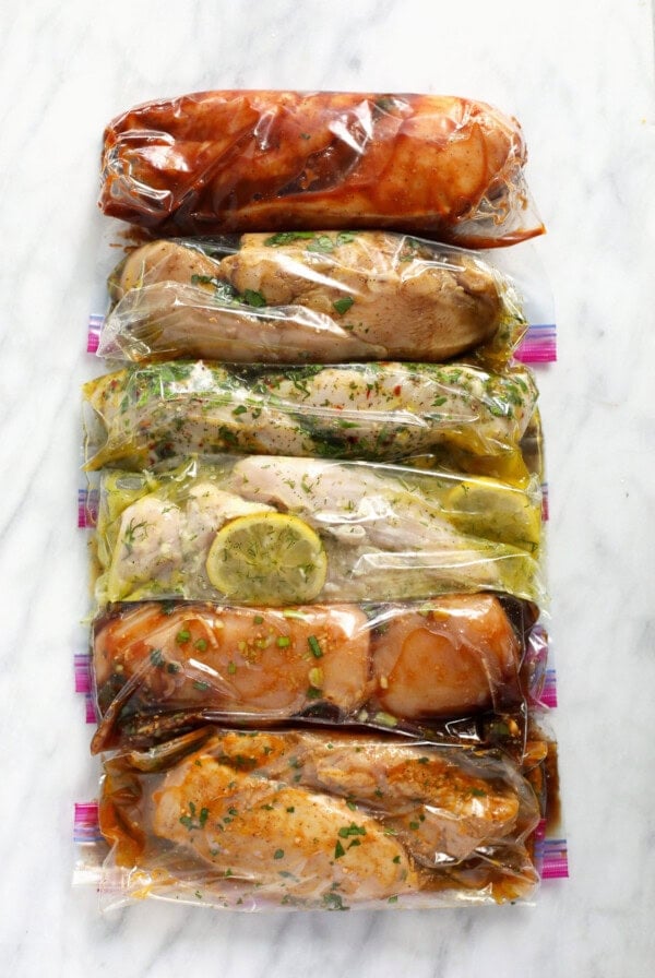 6 chicken marinades in plastic bags with chicken breasts.