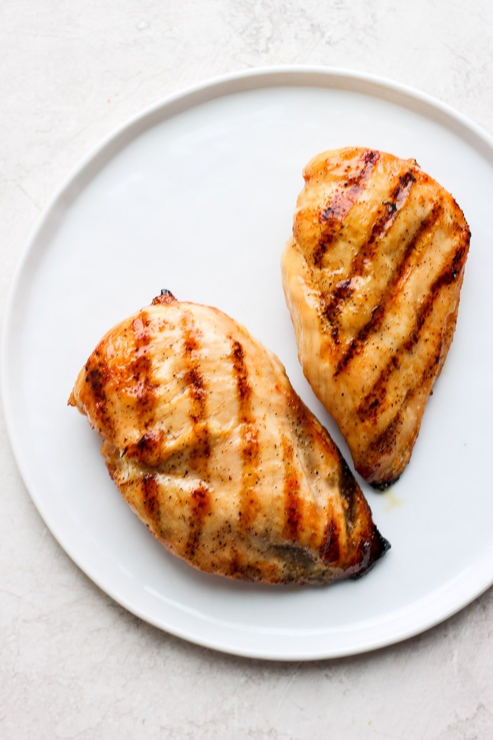 2 grilled chicken breasts on plate.