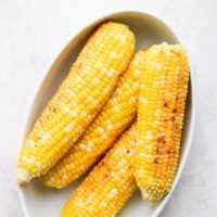 4 ears of corn in a bowl after being grilled