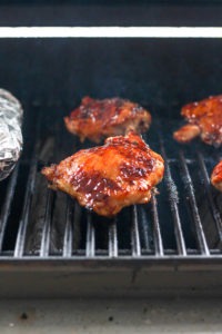 bbq chicken thighs on grill grates.