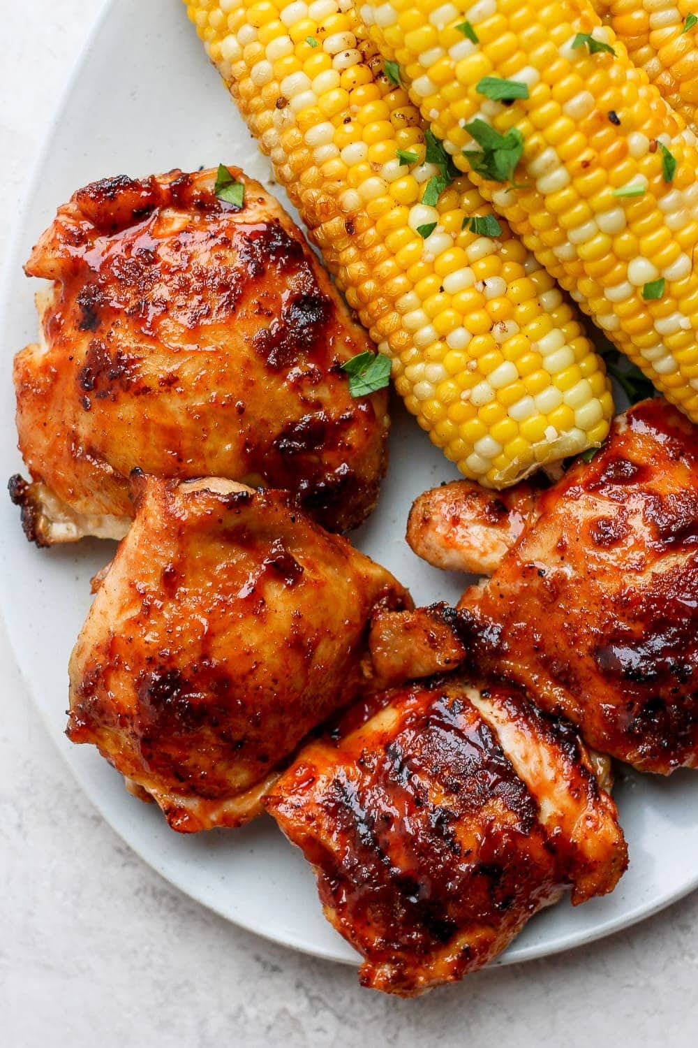chicken thighs with corn cob on plate.