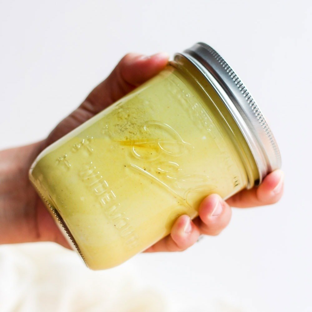 hand shaking jar of honey mustard dressing