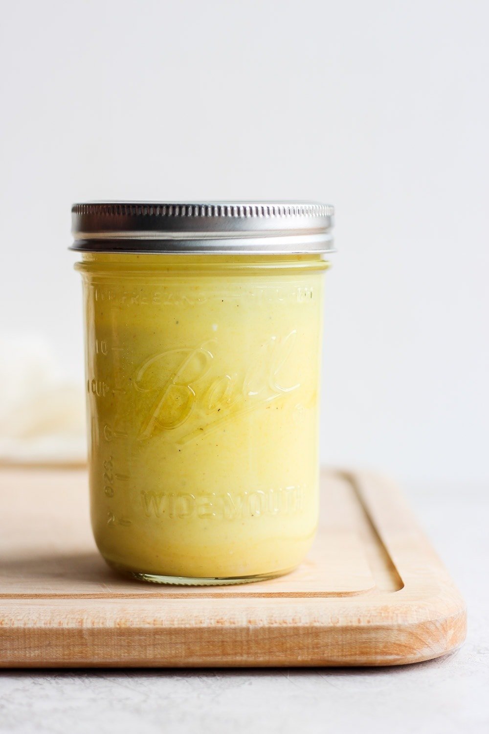 honey mustard dressing in jar on cutting board