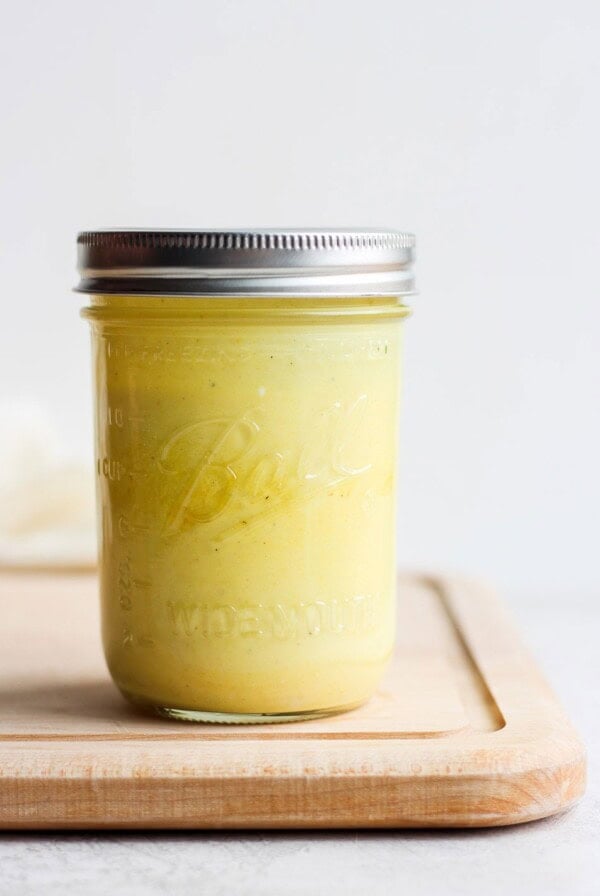 honey mustard dressing in mason jar on cutting board