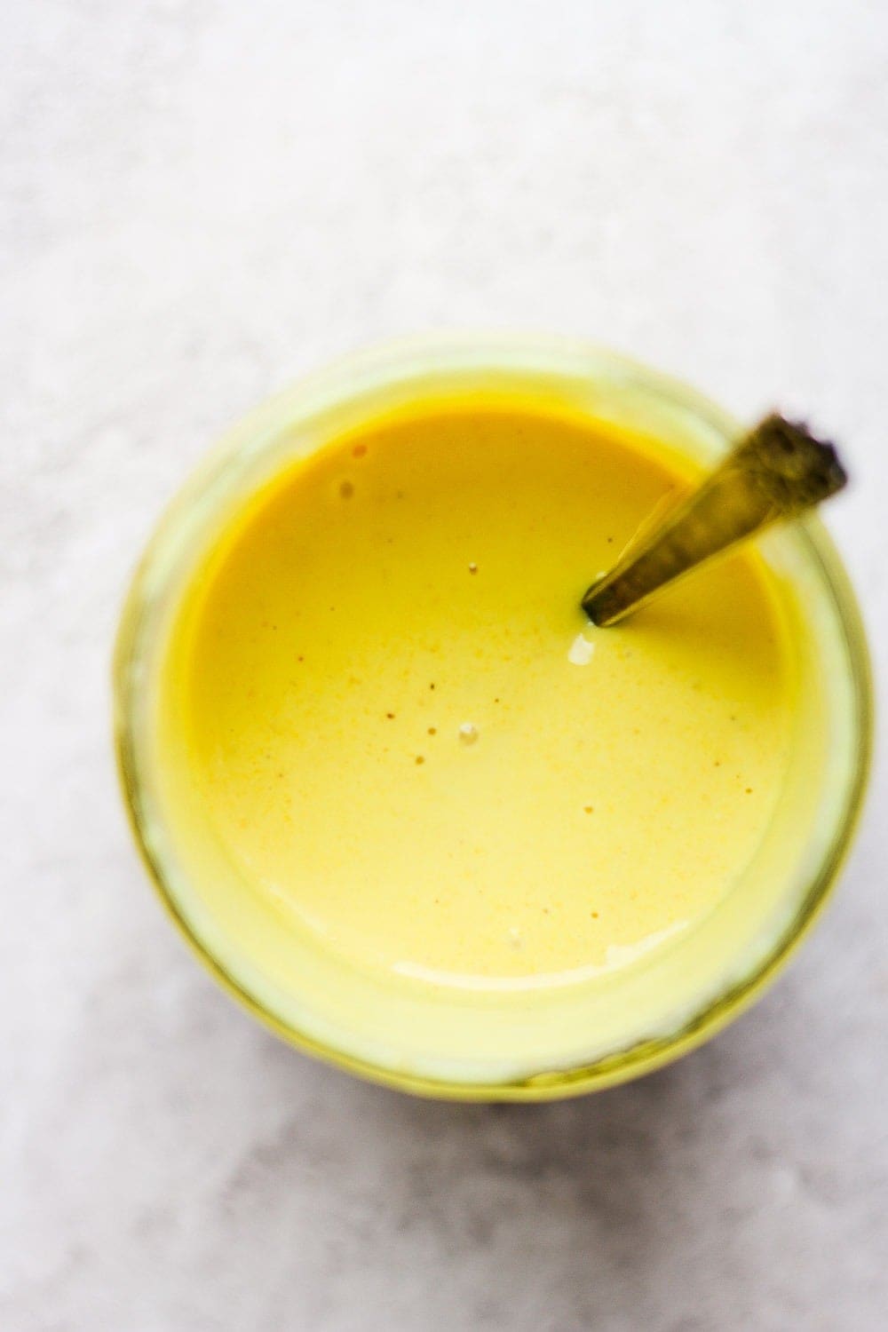 honey mustard dressing in jar with a spoon