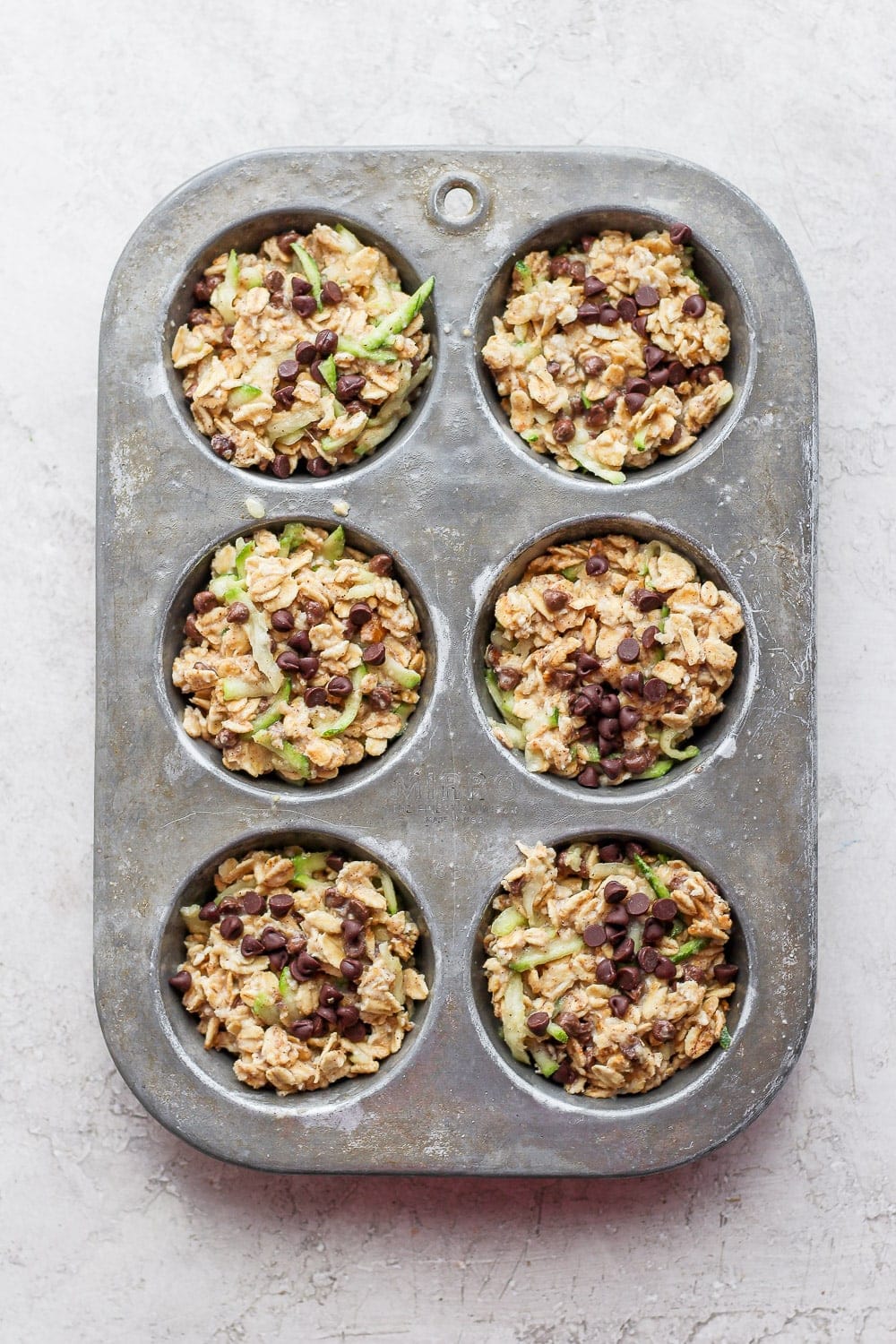 Zucchini oatmeal cups in a muffin tin. 