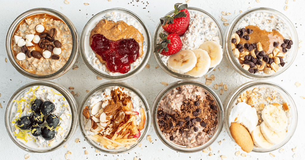 A group of jars filled with oatmeal, fruit, and nuts.