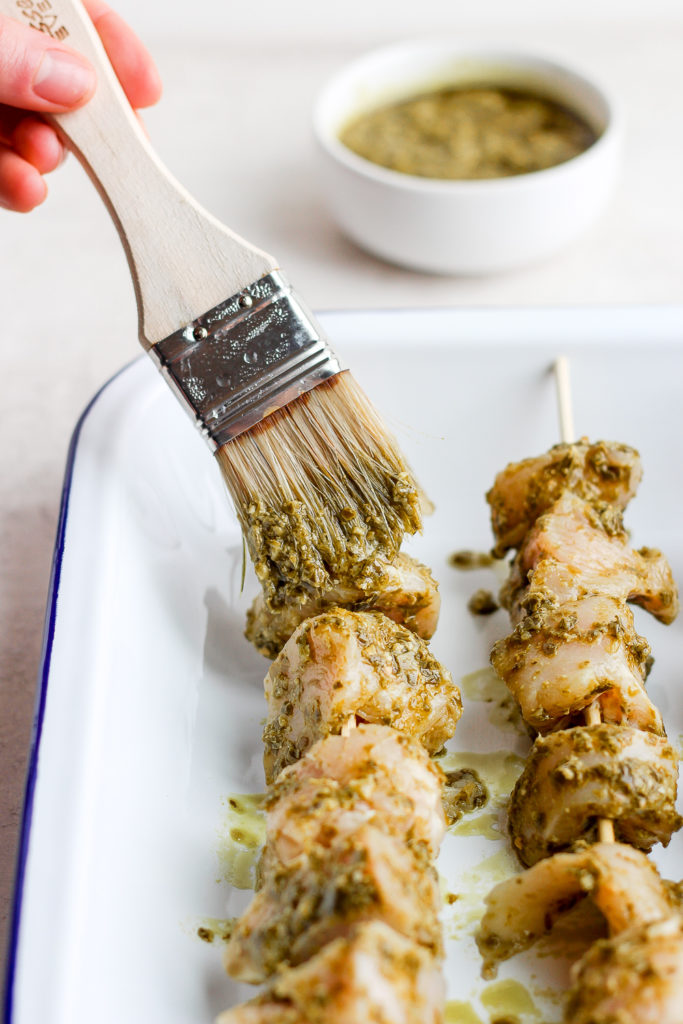 brush painting pesto onto chicken breast