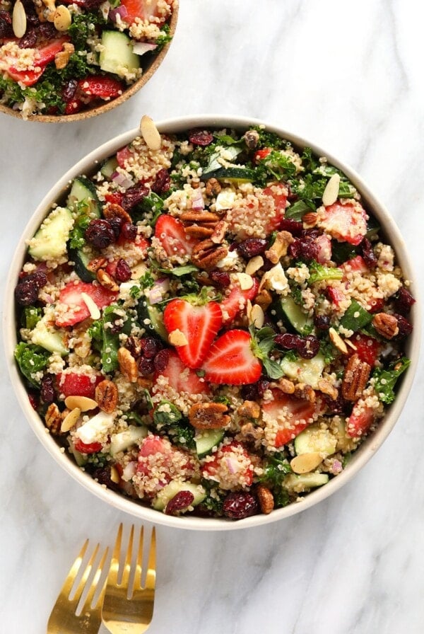 a bowl of quinoa salad with strawberries and pecans.