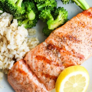 Grilled salmon on a plate with broccoli and rice.
