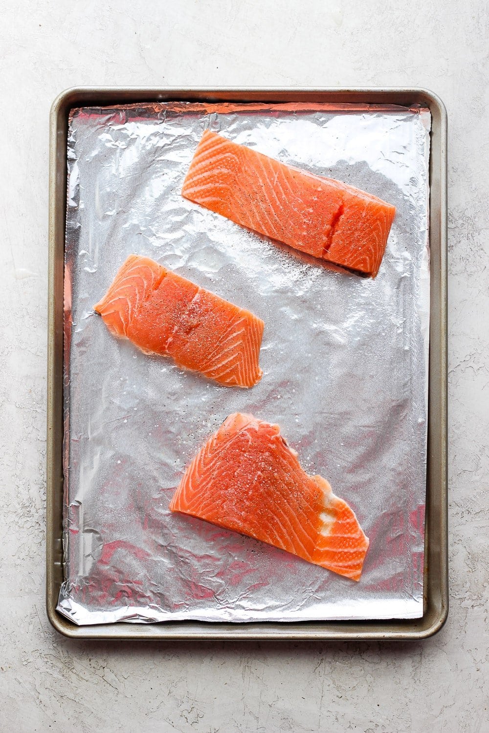 salmon filets on a sheet pan ready to be broiled