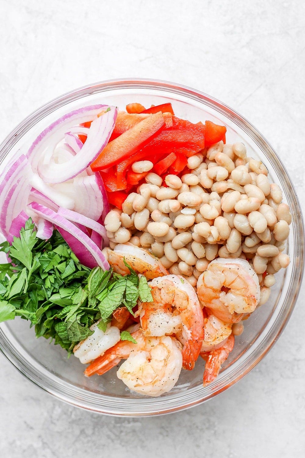 all ingredients for a healthy shrimp salad in a bowl before they're mixed together