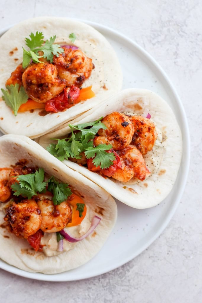 shrimp tacos topped with cilantro on a plate