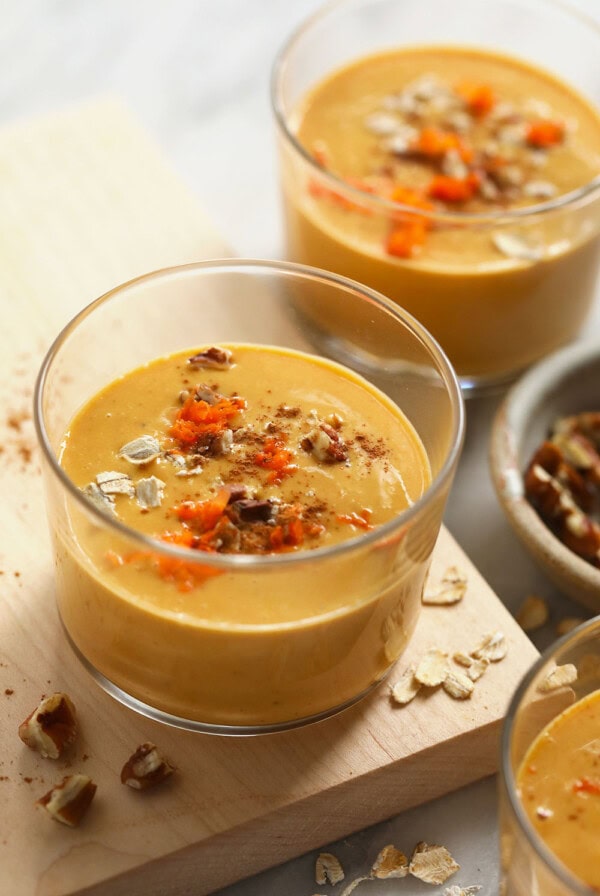 A bowl of carrot cake smoothie with nuts.