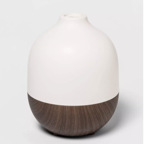 a white and brown vase on a white surface.