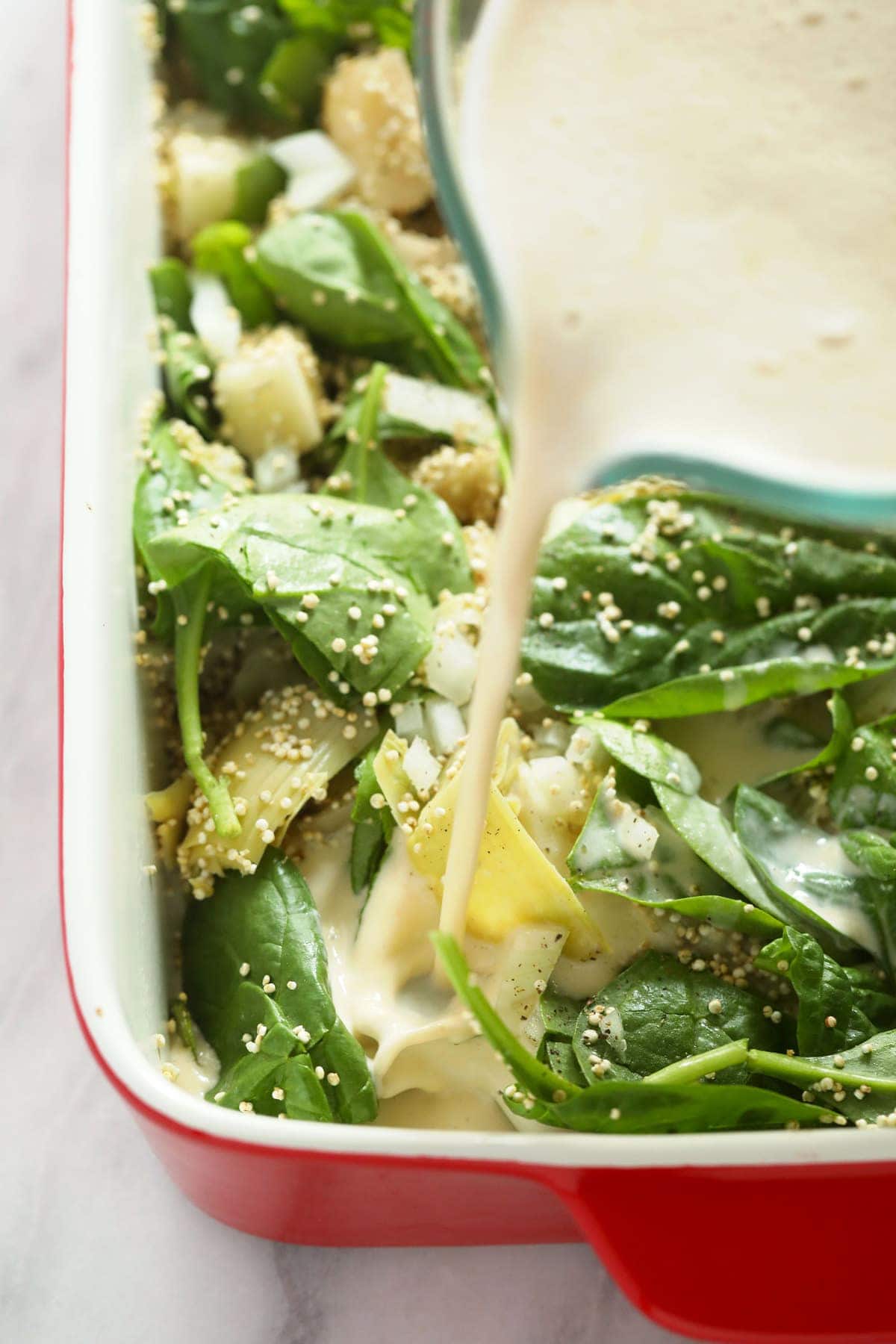 Pouring the sauce into this quinoa casserole. 