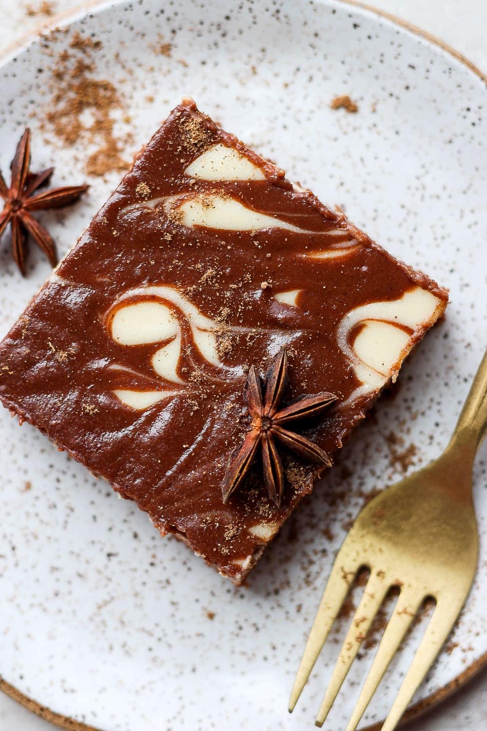 A chocolate chai cheesecake bar on a plate. 