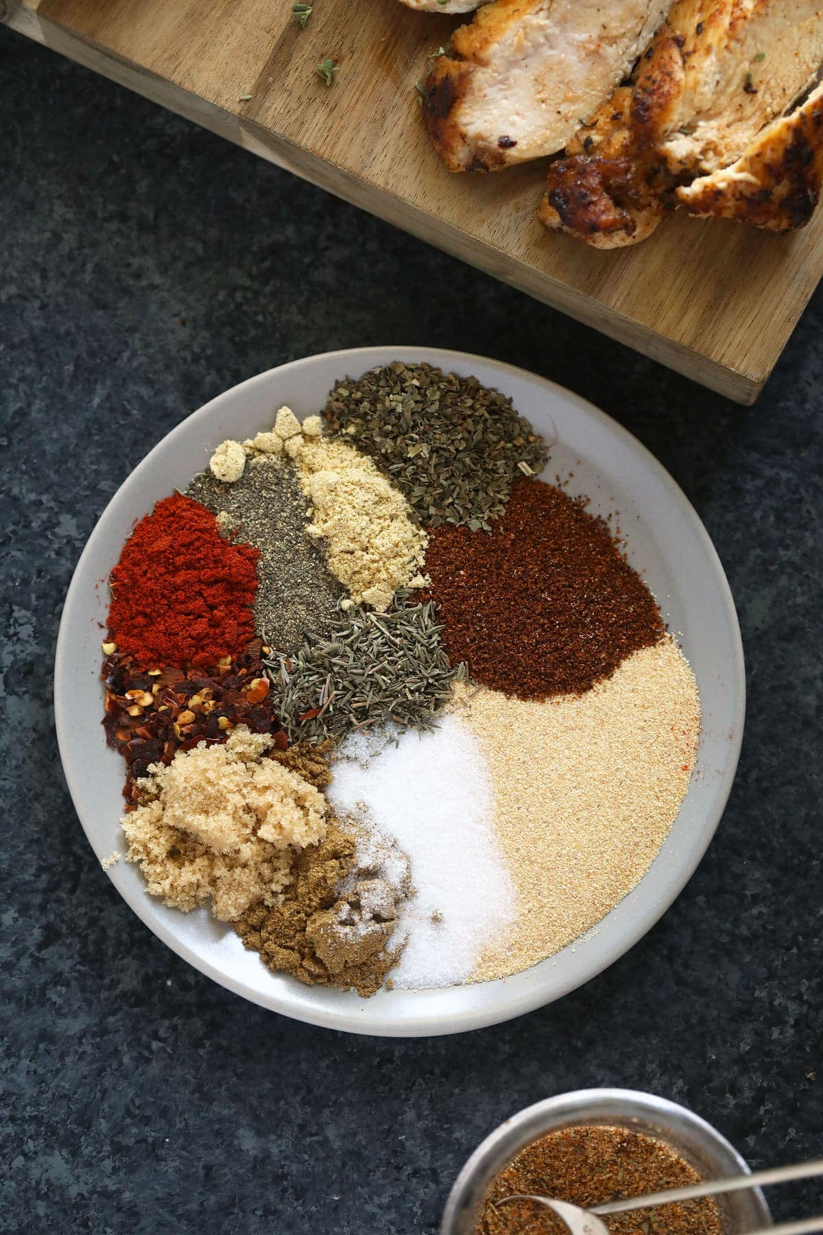 All of the different dried spices or herbs on a plate. 