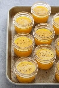 A tray of small jars filled with orange sauce inspired by sous vide egg bites.