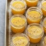A tray of small jars filled with orange sauce inspired by sous vide egg bites.