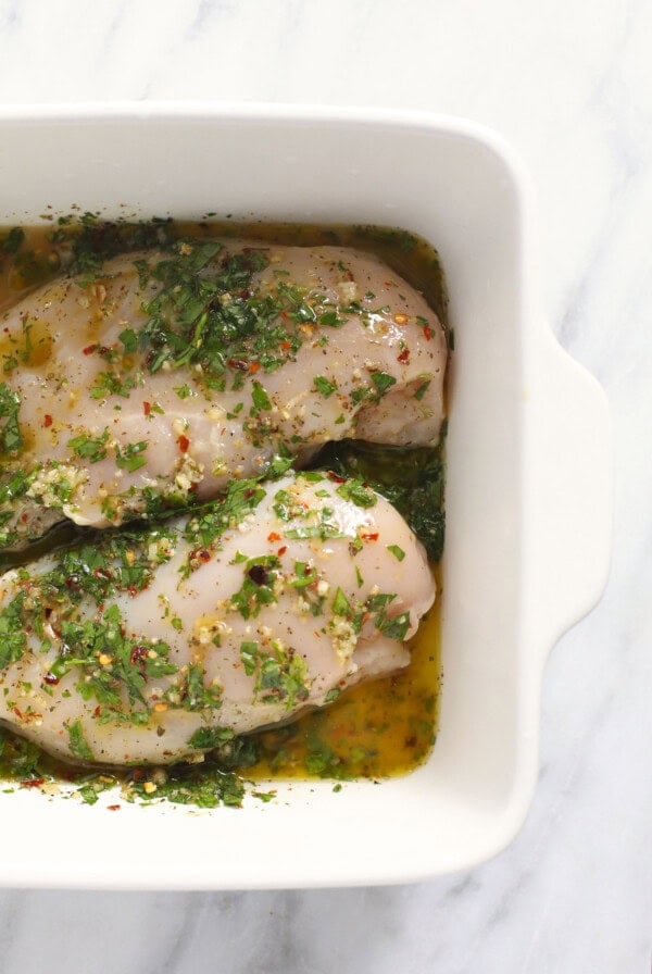 Chicken breasts marinated in an Italian herb blend, baked in a white dish.