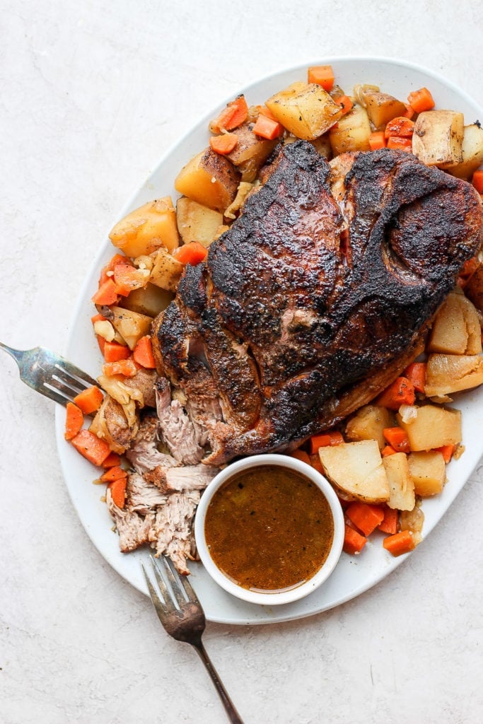 oven baked pork roast surrounded by potatoes and carrots