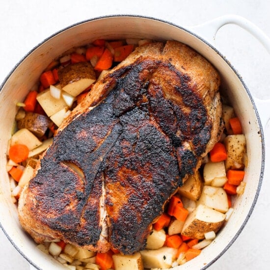 a baked pork roast with potatoes and carrots.