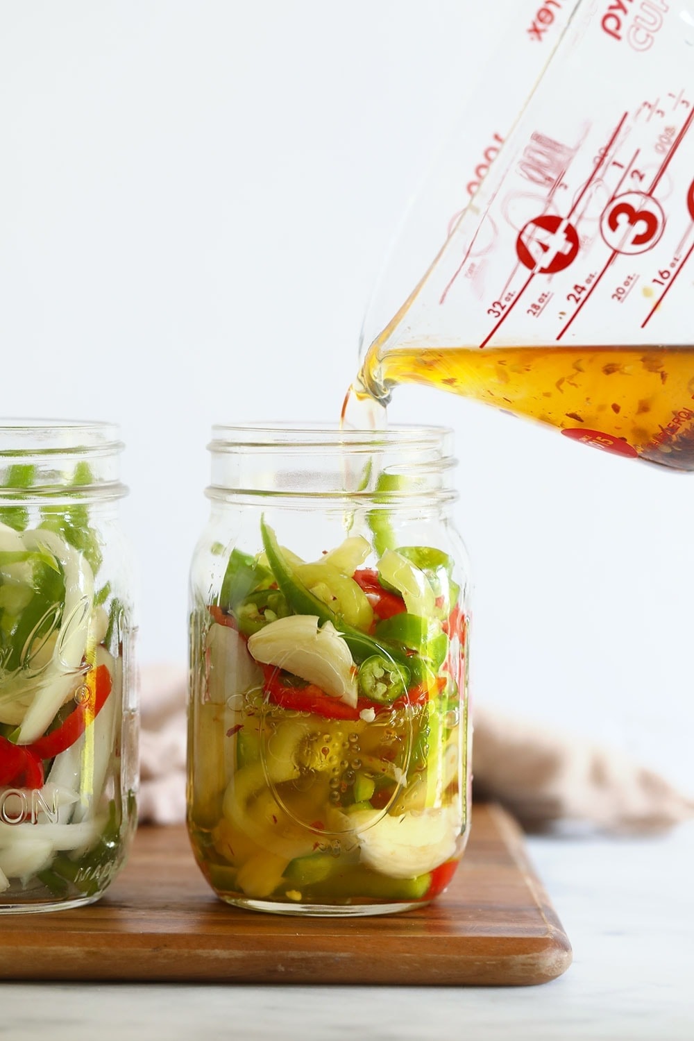 sliced peppers in a jar ready to be pickled