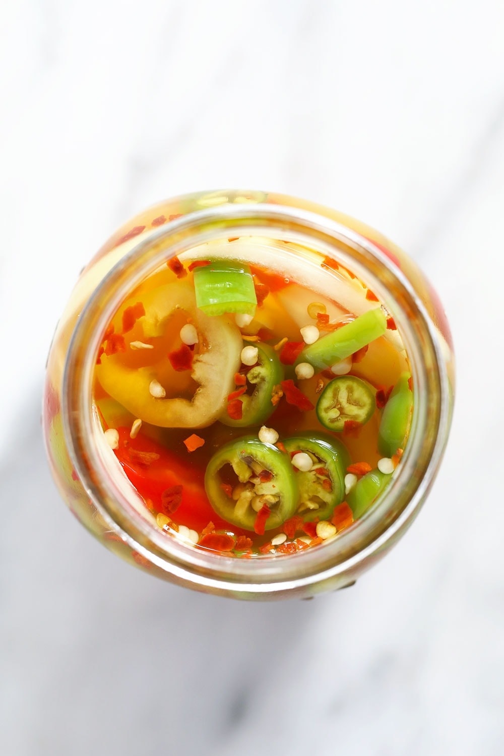 quick pickled peppers in a jar during the pickling process