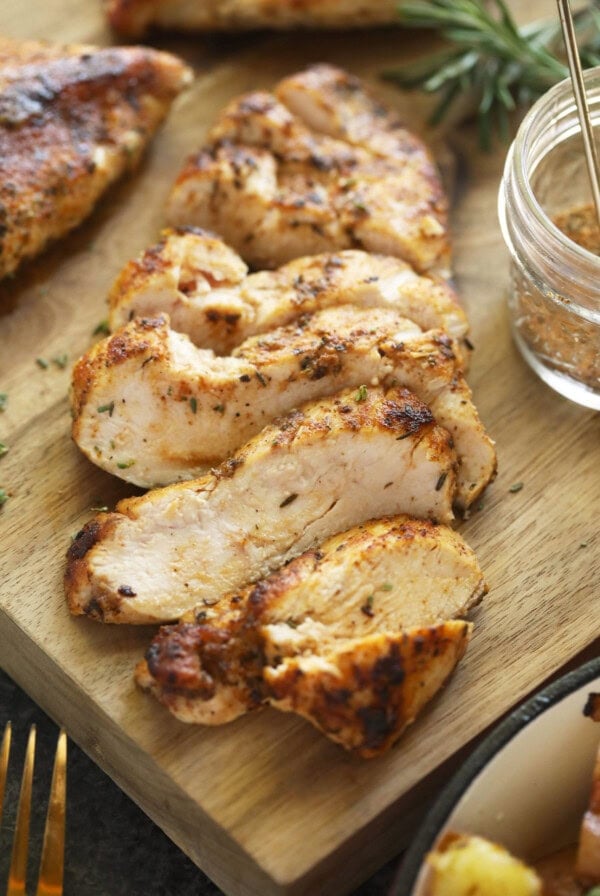 grilled chicken and potatoes on a cutting board.