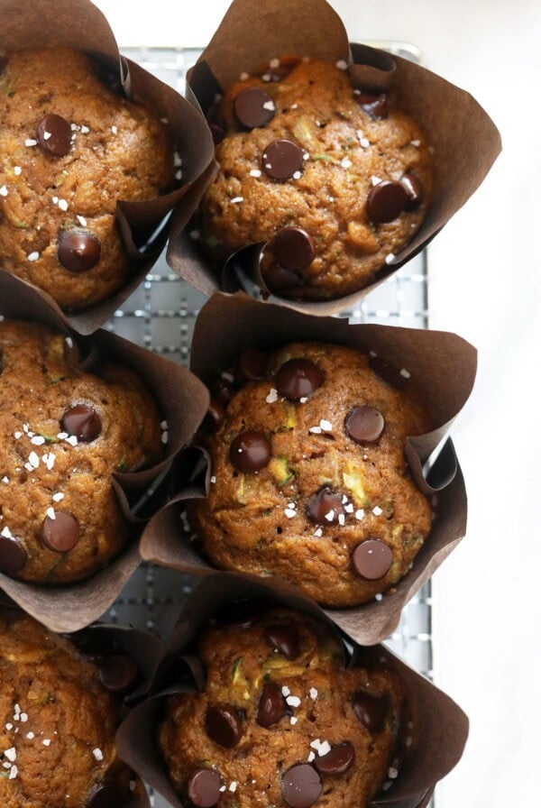 a tray of zucchini muffins with chocolate chips and pistachios.