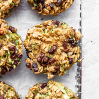 zucchini chocolate chip muffins on a baking sheet.