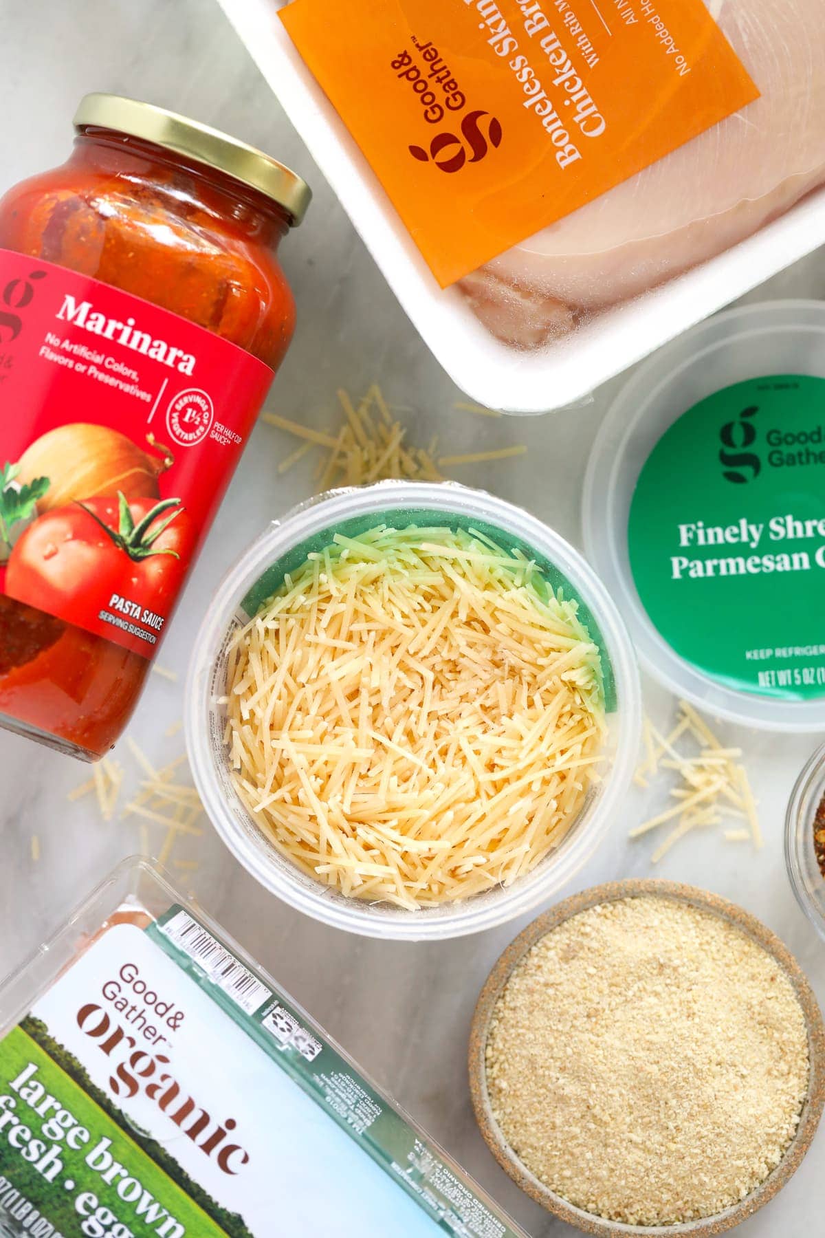 chicken parm ingredients - parmesan cheese, marinara sauce, and chicken breast