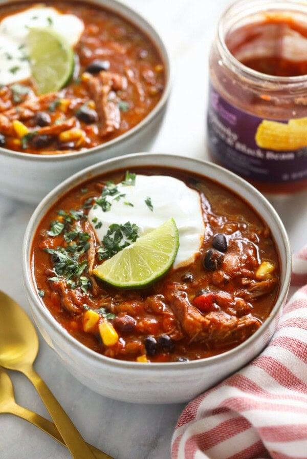 two bowls of pork chili with sour cream.
