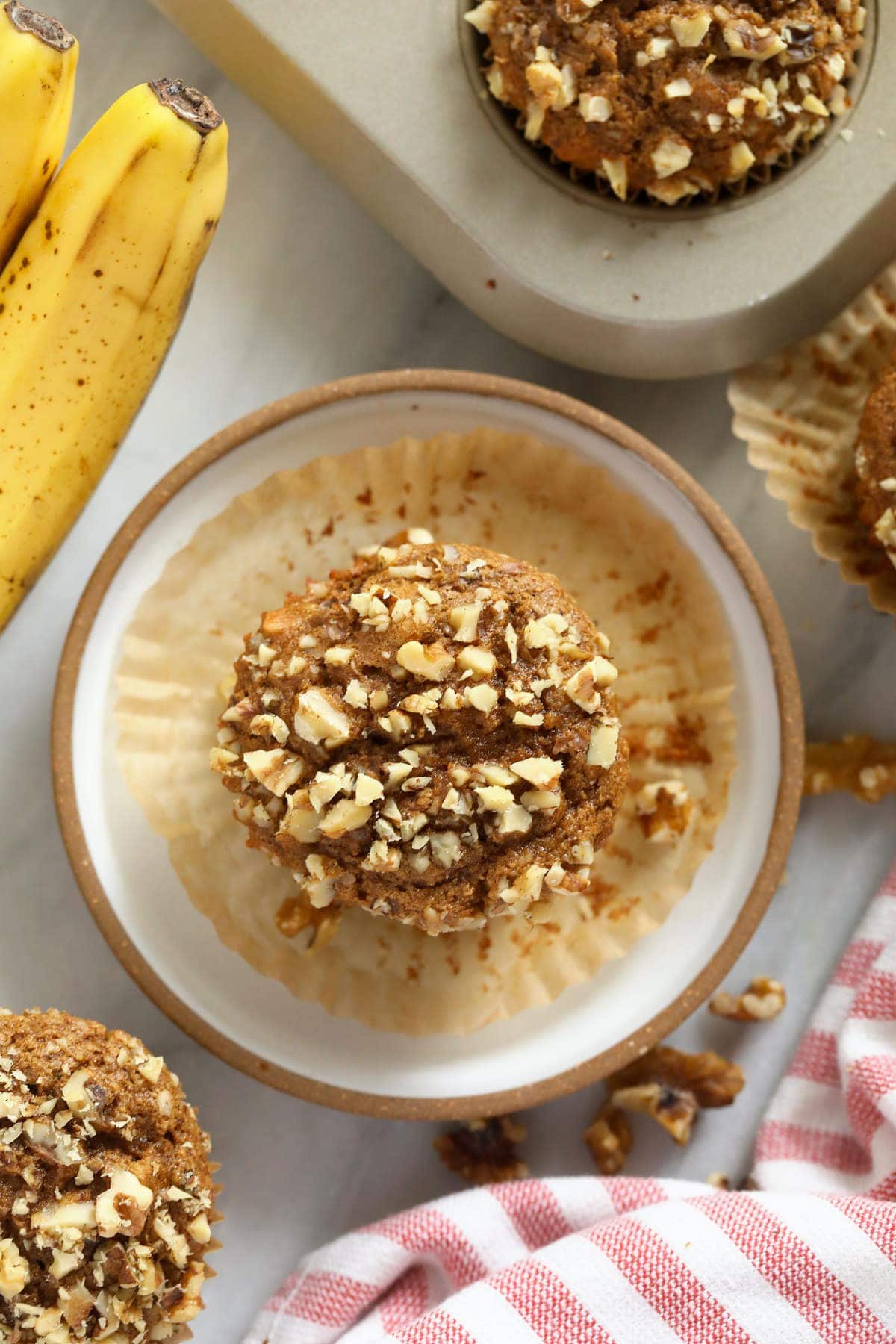 Banana nut muffins on a plate and in a muffin pan. 